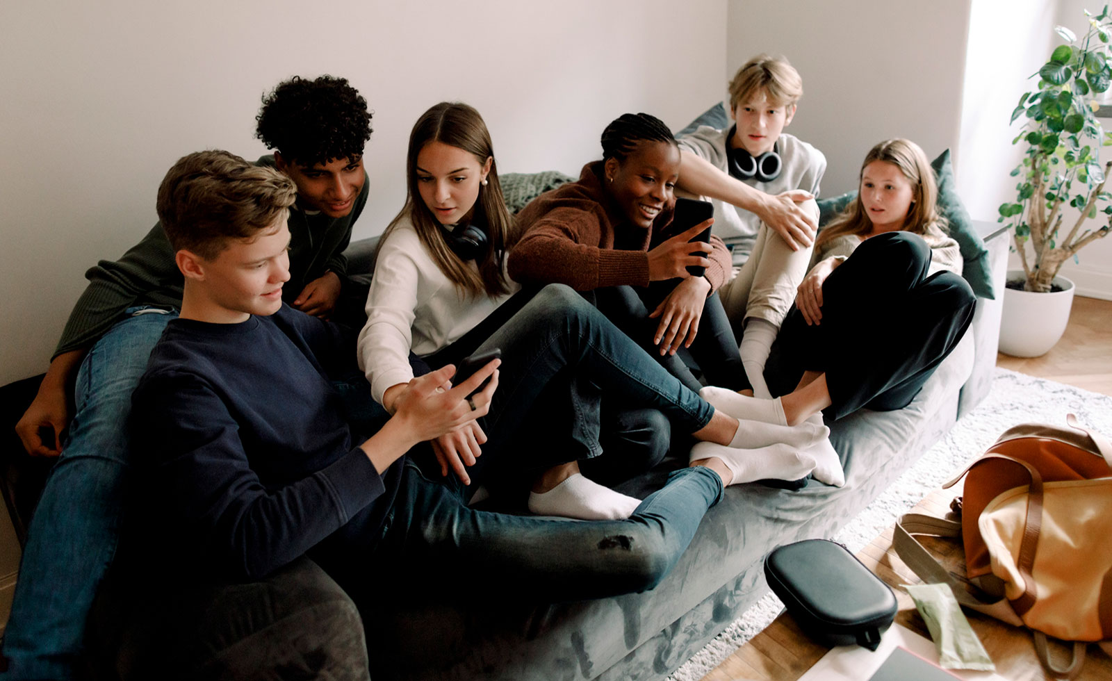 Group of Gen Z friends using smartphones together, showing social media engagement and TikTok-driven beverage trends