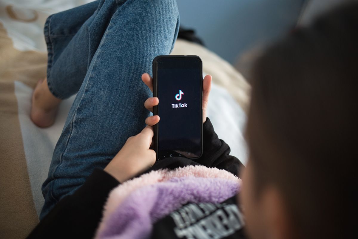 Person using TikTok app on smartphone, representing Gen Z digital behavior and viral beverage marketing trends